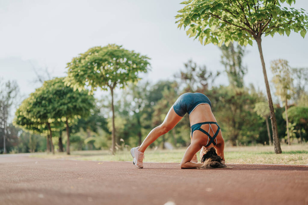 Ondersteboven in de natuur: atletische meisjes tonen kracht en flexibiliteit in headstand Pose - Foto, afbeelding