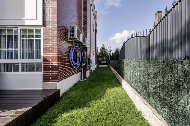 Pequena parcela alongada de grama que rodeia o perímetro de uma casa unifamiliar  - Foto, Imagem