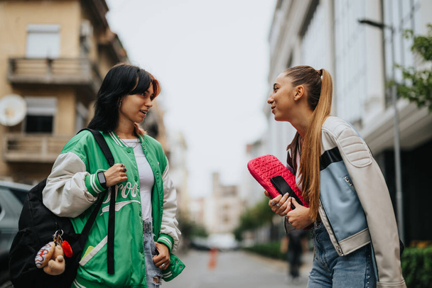 Sıradan giyinmiş liseli kızlar açık havada okuyor, okul konularını tartışıyor, ev ödevlerinde birbirlerine yardım ediyorlar ve şehir merkezinde bir sınava hazırlanıyorlar.. - Fotoğraf, Görsel