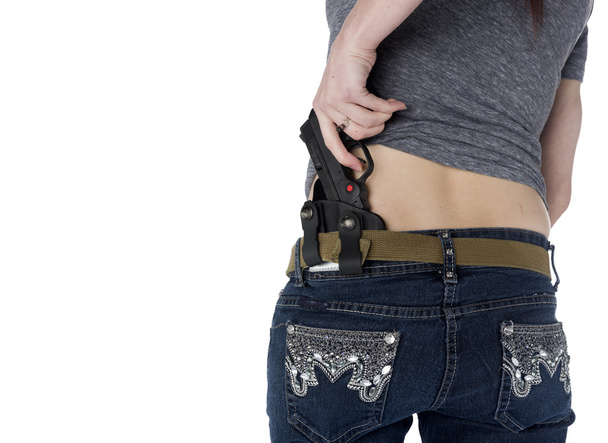 Woman Putting Hand Gun on her Hip Holster - Photo, image