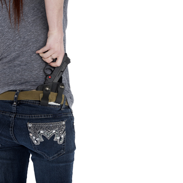 Woman Pulling her Hand Gun from Hip Holster - 写真・画像
