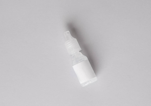 Bottiglia di collirio su sfondo grigio - Foto, immagini
