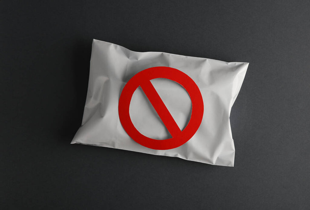 Paquete postal con un cartel de prohibición sobre fondo gris - Foto, Imagen