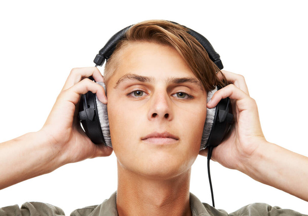 Man, face and portrait with headphones listening to music in audio streaming against a studio background. Closeup of male person, DJ or model with headset for podcast, beats or sound track on mockup. - Fotó, kép