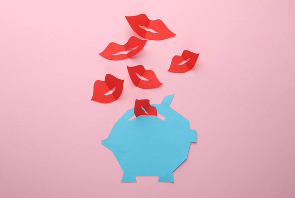 Hucha cortada en papel con labios sobre fondo rosa. San Valentín, economía, negocios y finanzas - Foto, imagen