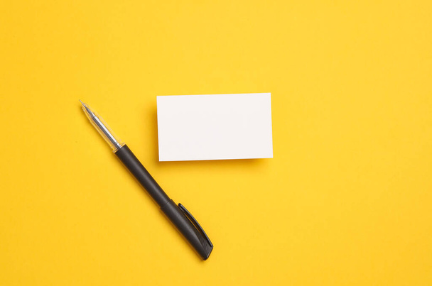Valkoinen käyntikortti kynällä keltaisella pohjalla - Valokuva, kuva