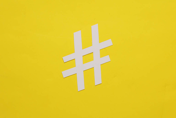 Hashtag de corte de papel sobre fondo amarillo. Vista superior - Foto, imagen