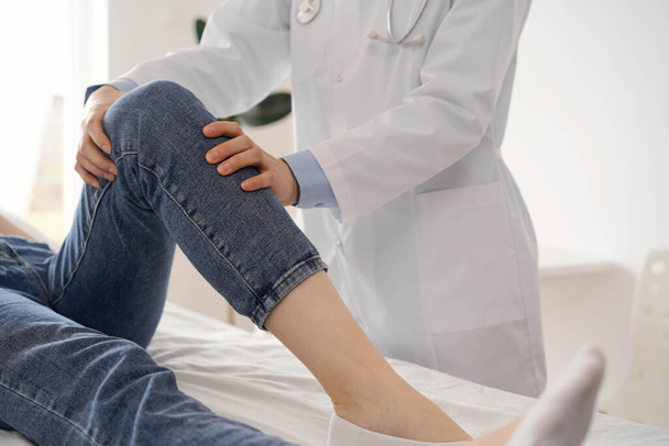Doctor and patient are at the usual medical inspection in the clinic. Therapist examines a young womans knee. Medicine concept . - Foto, immagini