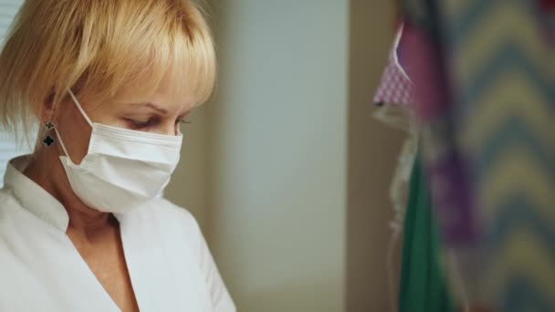 Vrouwelijke verpleegster met een beschermend masker die in het ziekenhuis werkt. Neonatale reanimatie. Vrouwelijke arts naast pasgeboren baby in incubator. Premature pasgeboren gezondheidszorg en medisch concept - Video