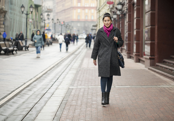 Young Asian woman walking on spring city in Russia - Фото, изображение