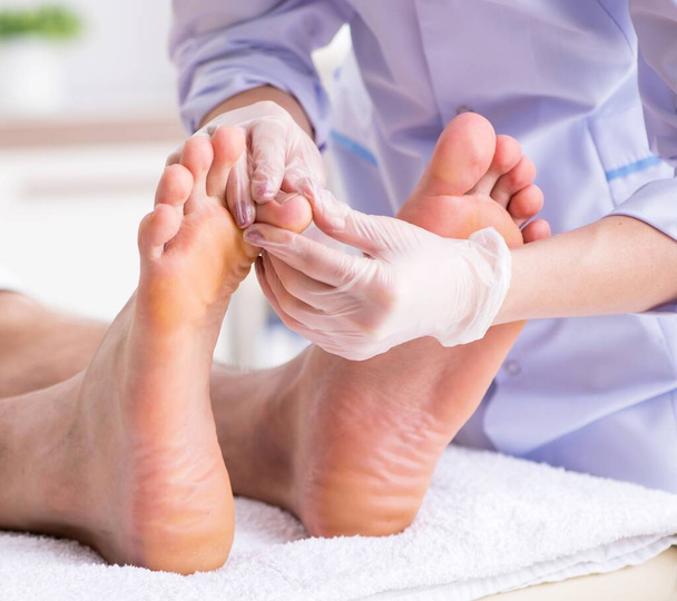 El podólogo que trata los pies durante el procedimiento
 - Foto, Imagen