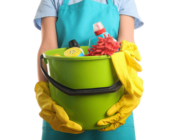 Чистящий работник держит ведро с чистящими средствами на белом фоне - Фото, изображение