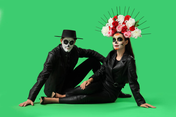 Nuori pari pukeutunut Meksikon Day of the Dead (El Dia de Muertos) vihreällä taustalla - Valokuva, kuva