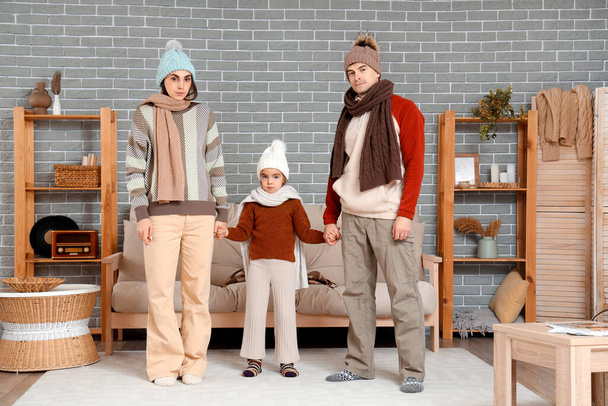 Familia congelada en ropa de abrigo en casa con falta de calefacción - Foto, Imagen