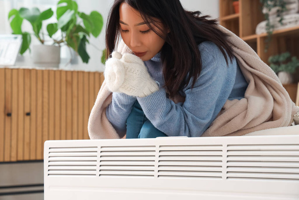 Jeune femme asiatique avec radiateur dans la chambre - Photo, image