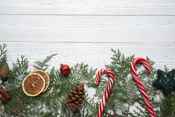 Рождественские ветки с едой и декором на белом деревянном фоне - Фото, изображение