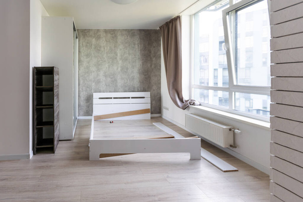 Assembling wooden bed in room. - Photo, Image
