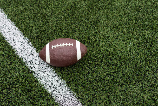 Football by a yard marker on a football field. High quality photo - Photo, Image