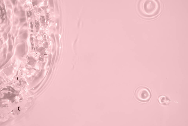 Streszczenie przezroczysta woda cień powierzchnia tekstura naturalne fala na różowym tle - Zdjęcie, obraz
