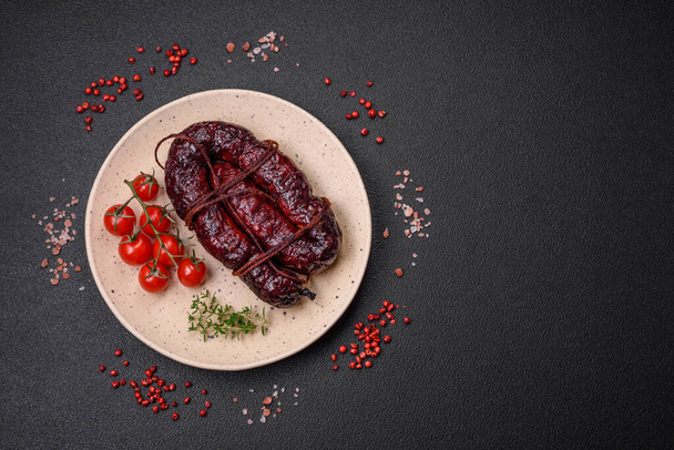 Delicious black blood sausage or black pudding with spices and herbs grilled on a black concrete background - Photo, Image