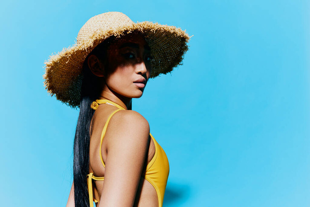 Mujer verano estudio azul lindo traje de baño moda belleza sombrero pelo asiático felicidad ojos modelo sonrisa primer plano amarillo alegría moda retrato uno - Foto, imagen