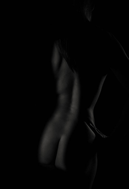 Arte ligero en el delgado cuerpo desnudo de una mujer. Blanco y negro. - Foto, imagen