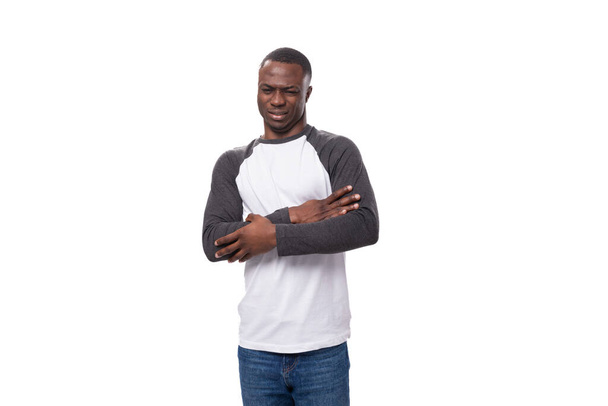 junger lässiger amerikanischer Mann mit Kurzhaarschnitt, bekleidet mit schwarz-weißem Sweatshirt und Jeans. - Foto, Bild