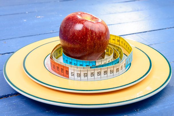 cinta de un metro alrededor de la manzana en el plato
 - Foto, imagen