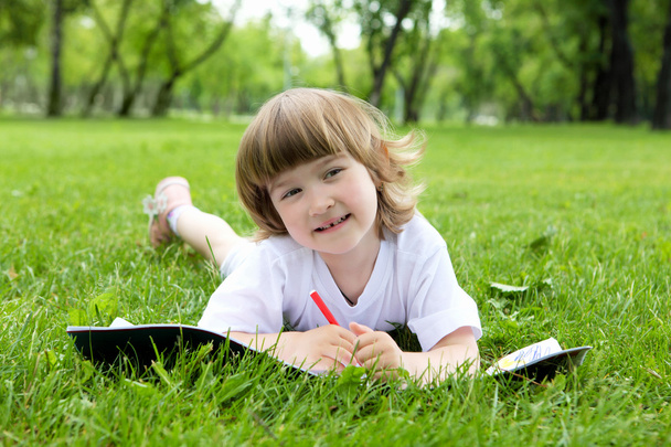 Portrait de petite fille lisant un livre dans le parc
 - Photo, image