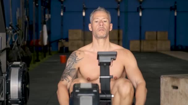 Homem de fitness usando máquina de remo no ginásio. CrossFit, fitness e esporte. - Filmagem, Vídeo