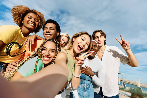 Chinesin macht an einem sonnigen Tag ein Selfie mit multiethnischen Freunden im Freien - Foto, Bild