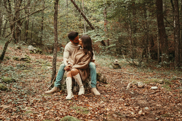 Young couple sitting in Autumn Leaves - Photo, Image
