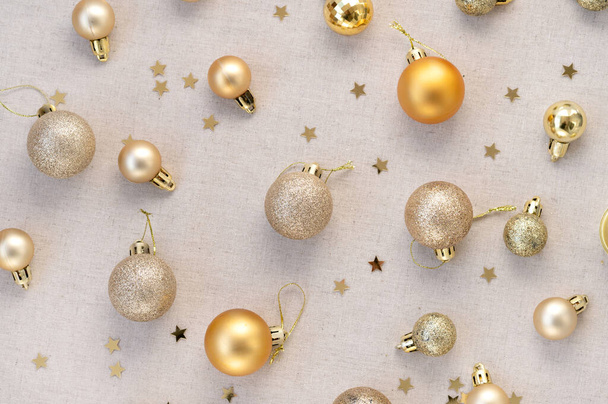 Ästhetisch elegantes Neujahrsbanner, gold- und bronzefarbene Weihnachtskugeln, Ornamente Muster flach auf neutralem beigem Leinenhintergrund. Luxuriöse minimalistische Urlaubsdesign-Vorlage. - Foto, Bild