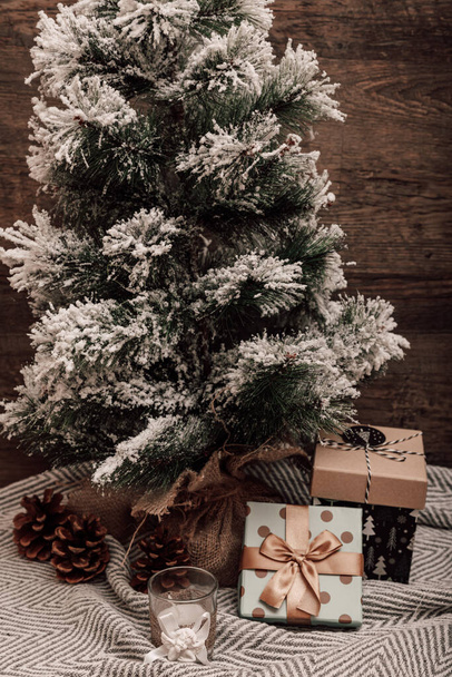 Weihnachtsbaum mit Geschenken und Kerze. Weihnachtsbaum auf dem Tisch. Hochwertiges Foto - Foto, Bild