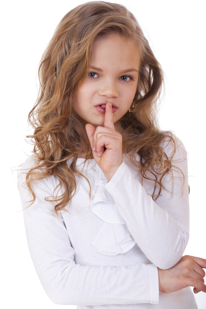 Little girl has put forefinger to lips as sign of silence - Foto, afbeelding