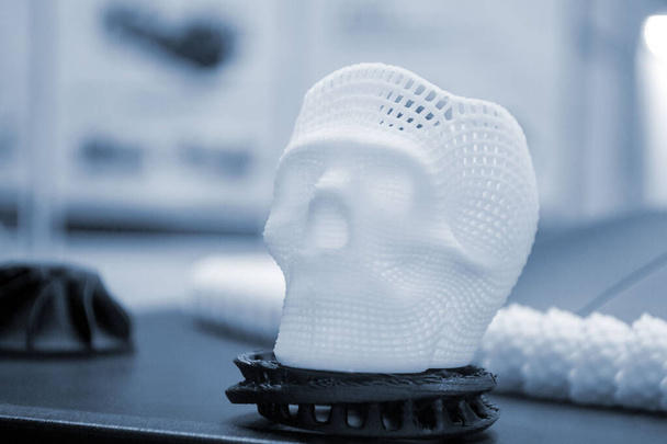 Petit prototype de crâne humain imprimé en 3D à partir de plastique blanc fondu sur plan rapproché. Modèle tridimensionnel. Technologie médicale progressive additive. Nouvelle industrie de fabrication d'impression moderne. - Photo, image