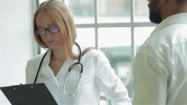 Attentive doctor listens to the patient and diagnoses in the best clinics. Smiling doctor listens to the patient and puts writes a prescription for the medication in the hospital. Polite doctor - Footage, Video