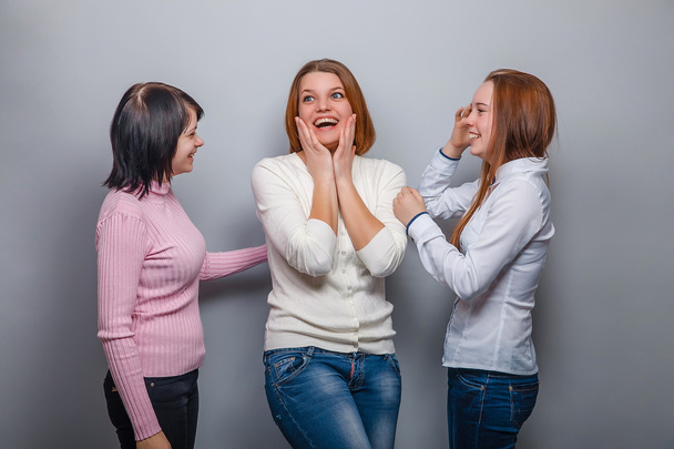 üç kadın kadın kadın arkadaş kız dedikodu söylentiler gri bir arka plan üzerinde sürpriz sürpriz - Fotoğraf, Görsel