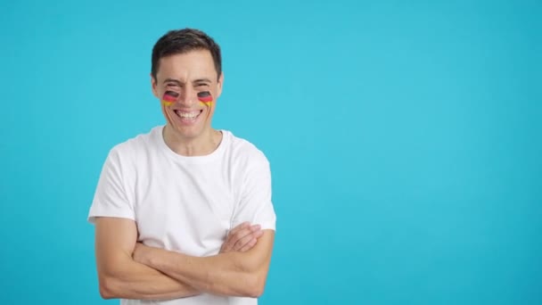 Video in studio met chroma van een man met een Duitse vlag op gezicht geschilderd glimlachend met gekruiste armen - Video