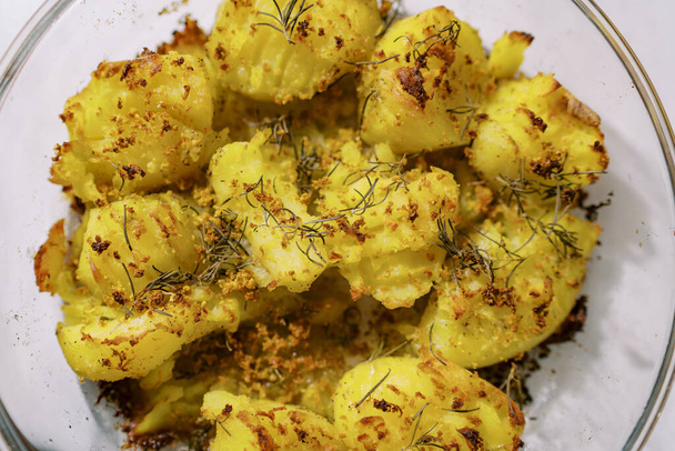 Backkartoffeln mit goldener Kruste und Gewürzen liegen auf einem Teller. Ansicht von oben. Hochwertiges Foto - Foto, Bild