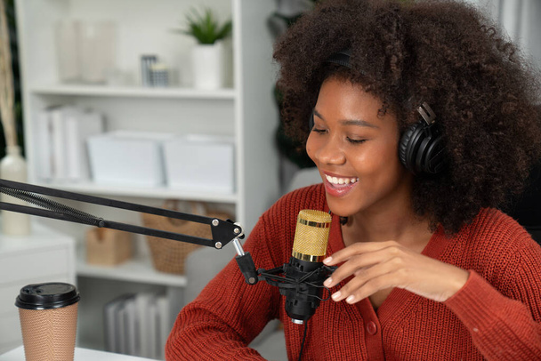 Hostitelský kanál krásné africké ženy mluví v on-line vysílání výuky marketingu vlivný, s posluchači v vysílání nebo on-line. Pojem kdekoliv na pracovišti. Tastemaker. - Fotografie, Obrázek