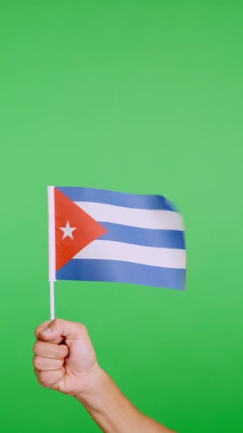 Slow motion video in studio with chroma of a hand lifting a cuban pennant while waving by the wind - Video