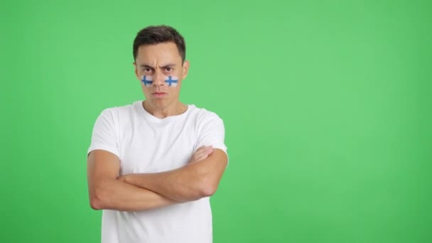 Video en estudio con croma de un hombre digno y serio con bandera finlandesa pintado en la cara mirando a la cámara con dignidad - Imágenes, Vídeo
