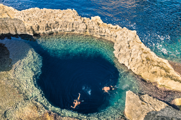Buraco azul profundo no mundialmente famoso Azure Window na ilha de Gozo - Maravilha da natureza mediterrânica na bela Malta - Mergulhadores turísticos irreconhecíveis nadando para a caverna de água de aventura
 - Foto, Imagem