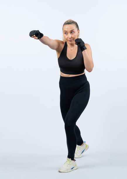 全身の長さショット運動とスポーティなシニアの女性は,ボクシングと孤立した背景に拳の姿勢をパンチ. 退職後の健康的なアクティブな体格とボディケアライフスタイル. クロート - 写真・画像