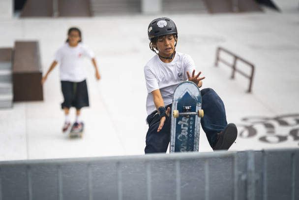 24 september 2023, Almada, Portugal - center of city - teen kid boy skater jumping on rail, performing a jump onto a rail amidst a concrete setting. - Fotó, kép