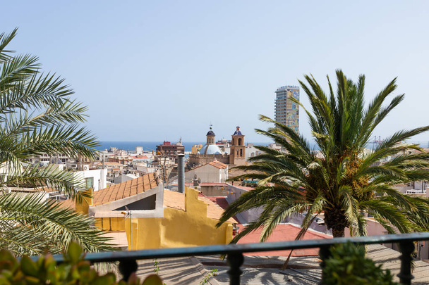 ALICANTE, SPANJE - JULI, 5 2023: Alicante stad, panoramisch uitzicht vanuit de lucht, hotelgebouw, kerkdak op de achtergrond. Stadsgezicht, palmbomen, daken, Costa Blanca. - Foto, afbeelding