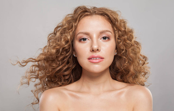 Cheerful redhead female model with wavy hairstyle. Pretty young woman with healthy curly hair closeup portrait - Photo, Image