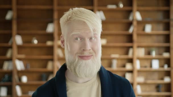 Closeup verraste het gezicht van een albino man in het kantoor. Blond, bewegende ogen. Jonge zakenman met wenkbrauwen. Portret van een blonde vent die grimmige dingen maakt. Geschokte gezichtsuitdrukking, slow motion - Video