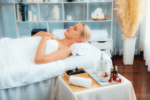Kaukaska klientka ciesząca się relaksującym antystresowym masażem spa i rozpieszczająca odpoczynkiem rekreacyjnym skóry w świetle dziennym w salonie spa w luksusowym kurorcie lub hotelu. Cichy zapach - Zdjęcie, obraz